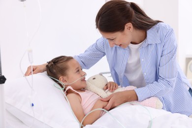 Mother and her little daughter on bed in hospital