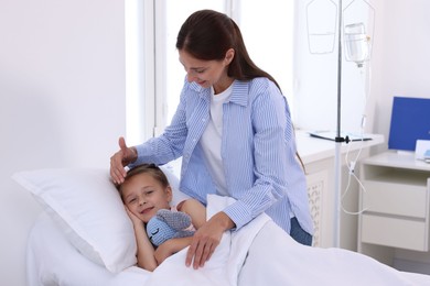 Mother and her little daughter on bed in hospital