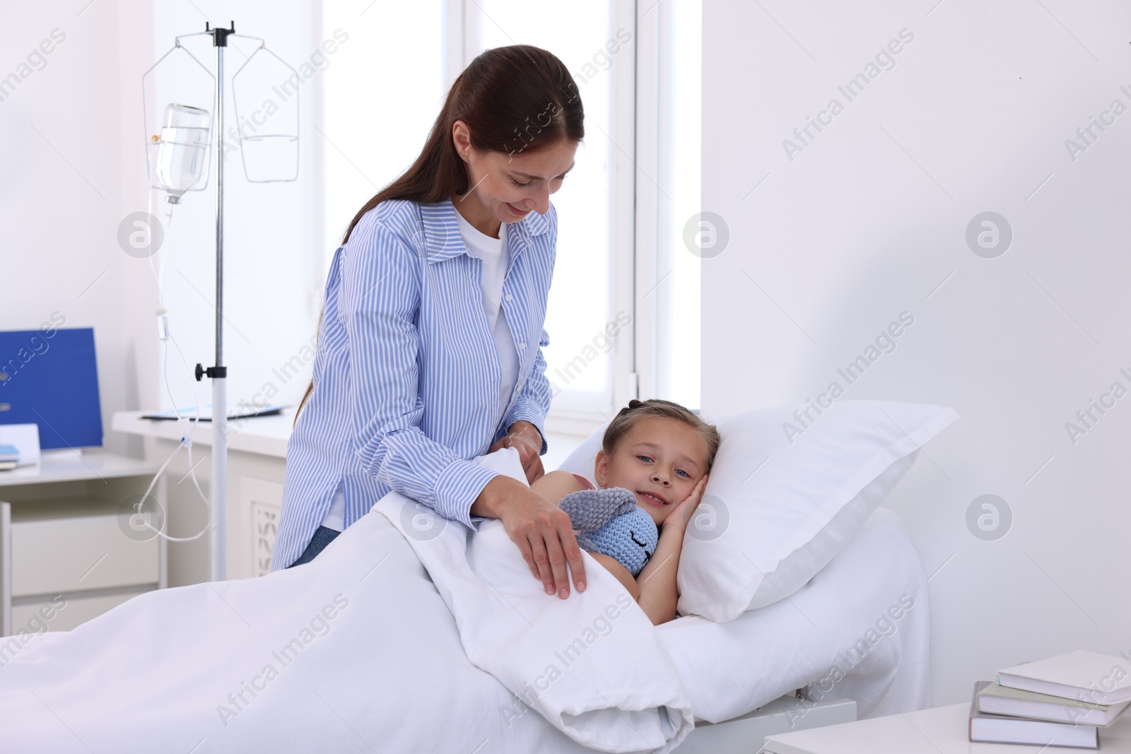 Photo of Mother and her little daughter on bed in hospital