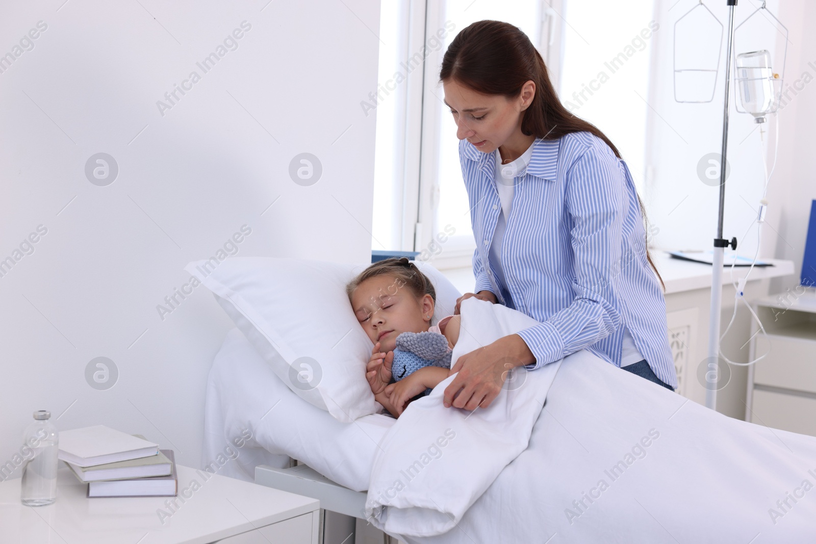 Photo of Mother and her little daughter on bed in hospital