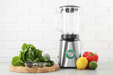 Photo of Blender and products on light table against white brick wall