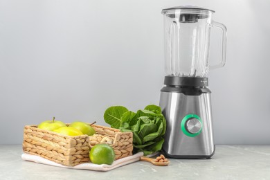 Blender and healthy products on grey marble table