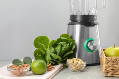 Photo of Blender and healthy products on grey marble table, closeup