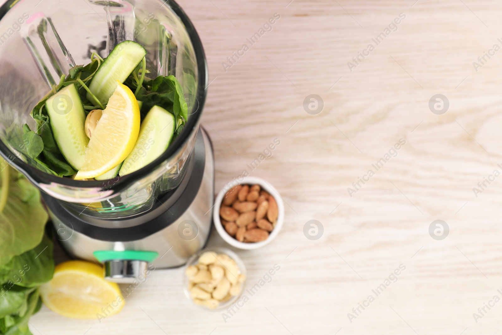 Photo of Modern blender with ingredients for smoothie on wooden table, top view. Space for text