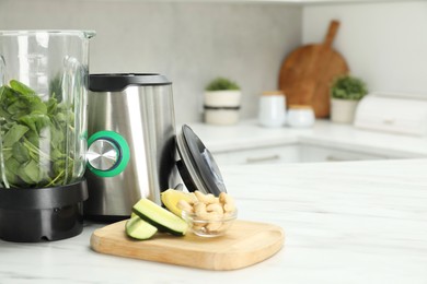 Modern blender with ingredients for smoothie on white marble table in kitchen. Space for text