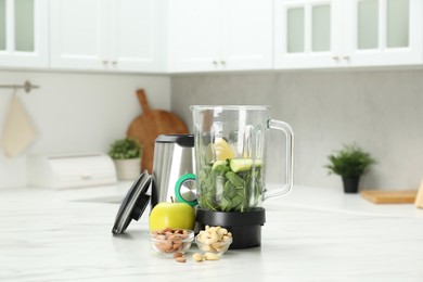 Photo of Modern blender with ingredients for smoothie on white marble table in kitchen