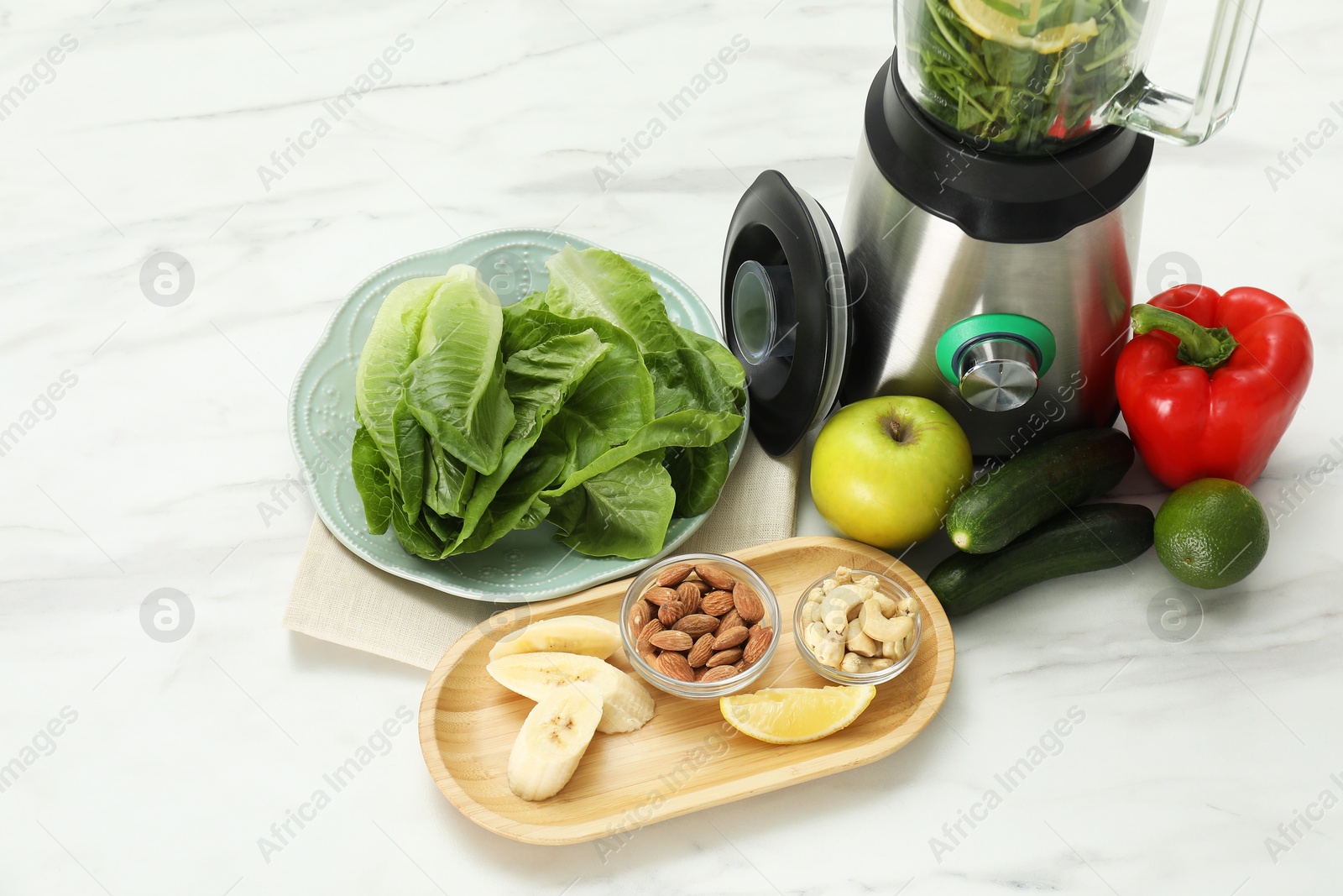 Photo of Modern blender with ingredients for smoothie at white marble table