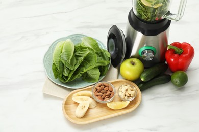 Photo of Modern blender with ingredients for smoothie at white marble table