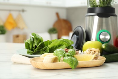 Modern blender with ingredients for smoothie on white marble table in kitchen, closeup