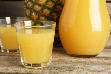 Photo of Tasty pineapple juice and fresh fruit on wooden table, closeup