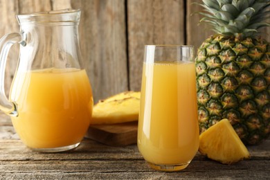 Photo of Tasty pineapple juice and fresh fruit on wooden table, closeup