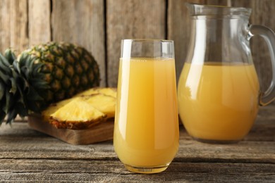 Photo of Tasty pineapple juice and fresh fruit on wooden table, closeup