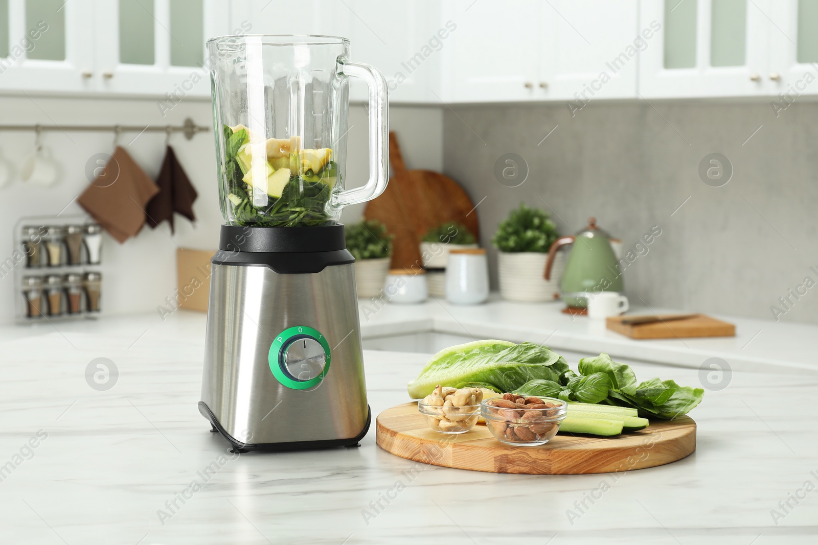 Photo of Modern blender with smoothie and ingredients on white marble table in kitchen