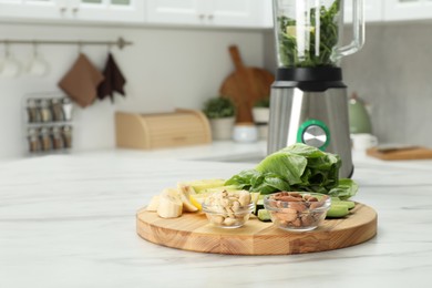 Photo of Modern blender with smoothie and ingredients on white marble table in kitchen. Space for text