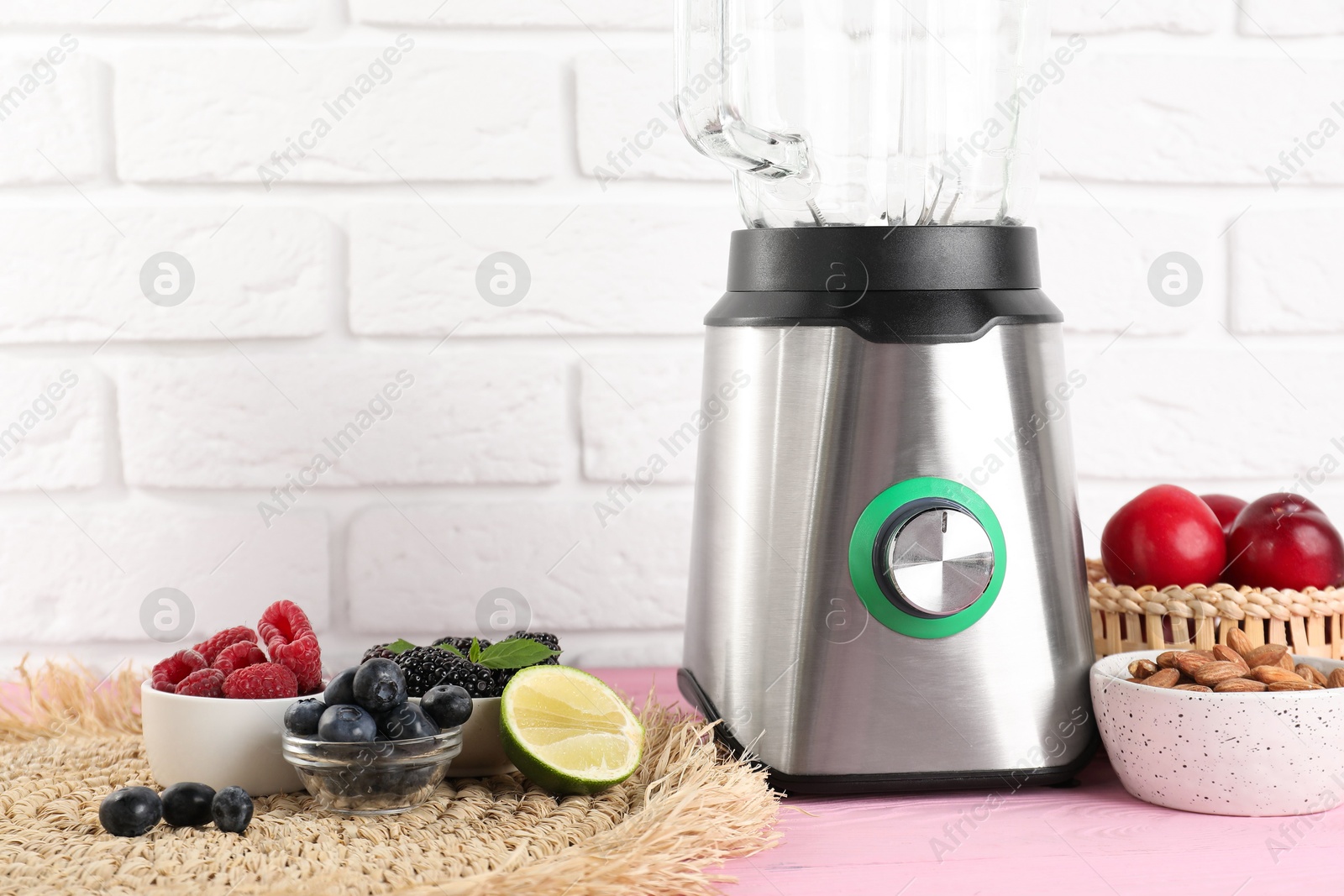 Photo of Blender and fresh ingredients on pink wooden table