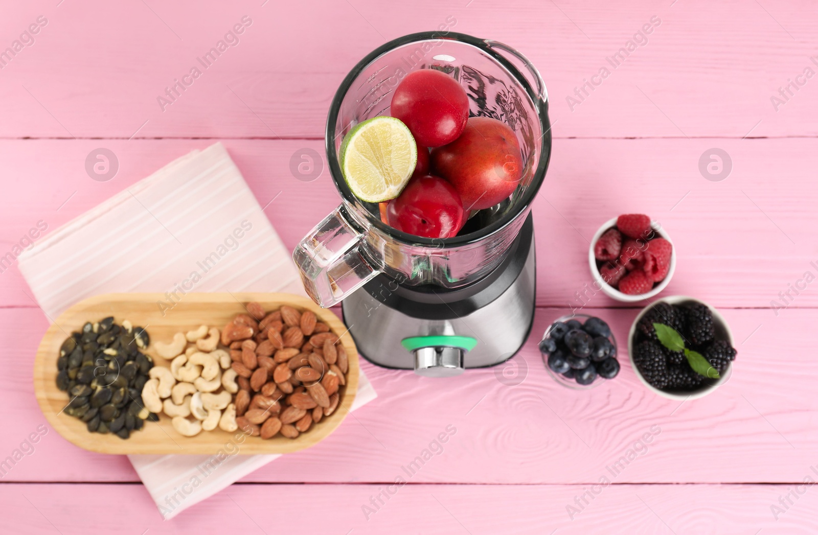 Photo of Blender and fresh ingredients on pink wooden table, top view