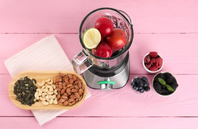 Blender and fresh ingredients on pink wooden table, top view