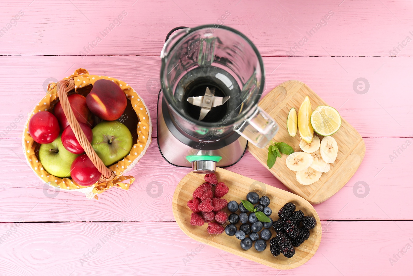 Photo of Blender and fresh ingredients on pink wooden table, top view