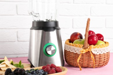 Photo of Blender and fresh ingredients on pink wooden table