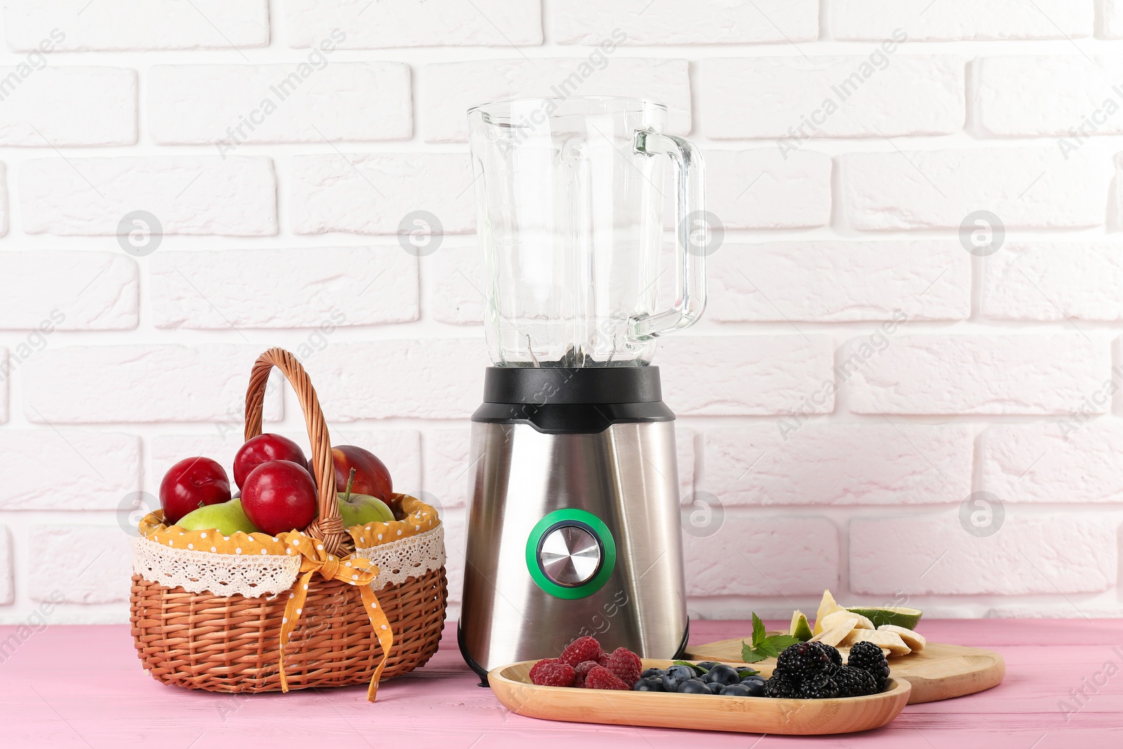 Photo of Blender and fresh ingredients on pink wooden table