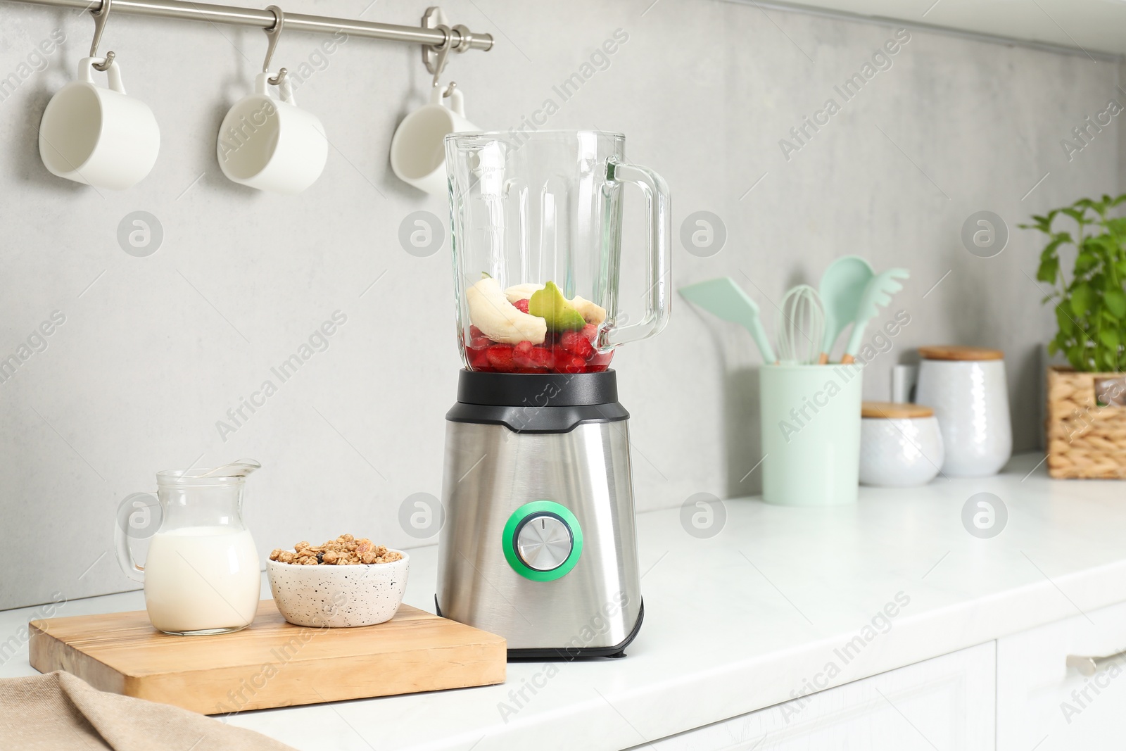 Photo of Blender and fresh ingredients on white countertop in kitchen