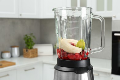 Photo of Blender with fresh ingredients in kitchen, space for text