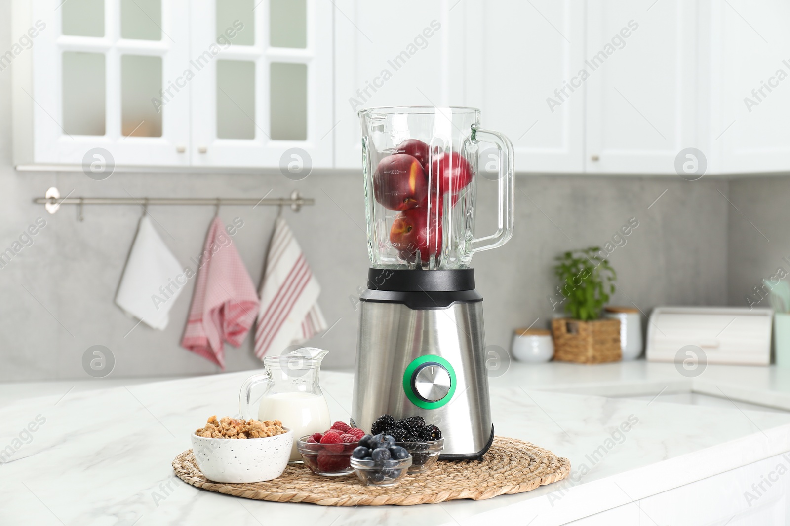 Photo of Blender and fresh ingredients on white marble table in kitchen