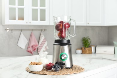 Blender and fresh ingredients on white marble table in kitchen