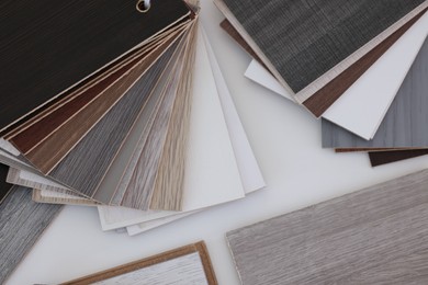 Photo of Different samples of wooden flooring on white table, top view