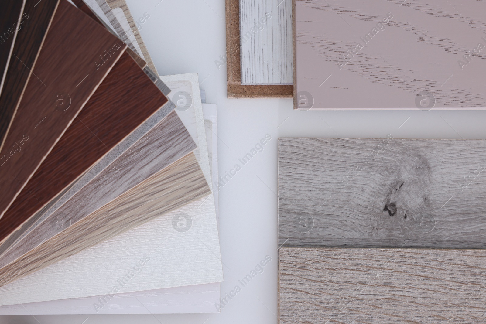 Photo of Different samples of wooden flooring on white table, top view