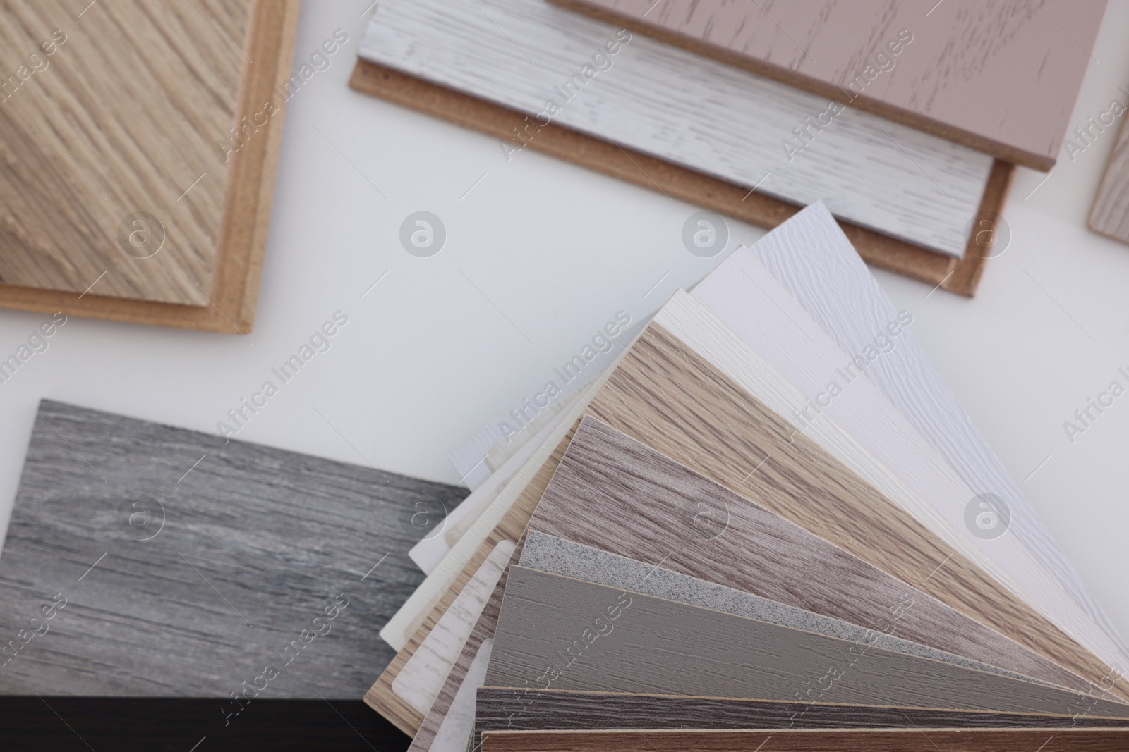 Photo of Different samples of wooden flooring on white table, top view