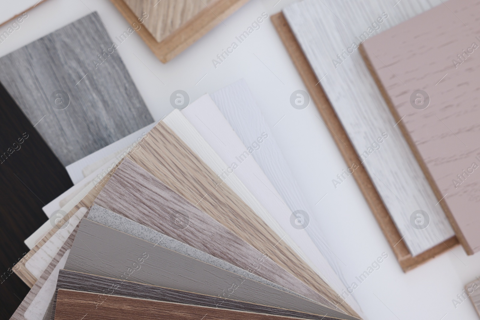 Photo of Different samples of wooden flooring on white table, top view