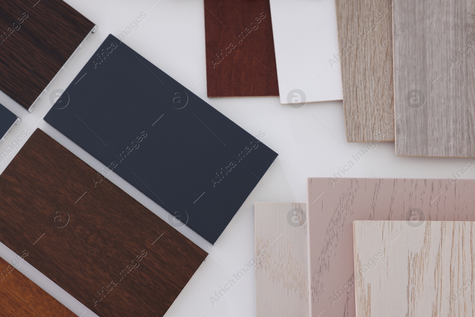 Photo of Different samples of wooden flooring on white table, top view