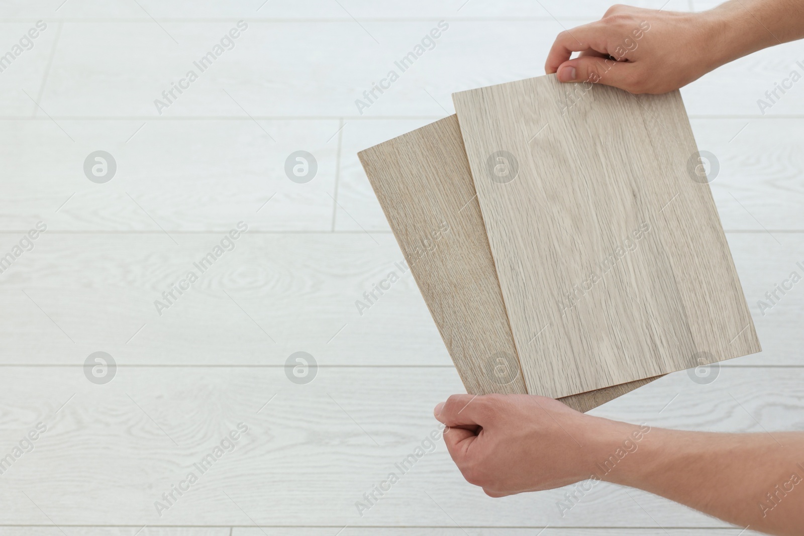 Photo of Man with samples of wooden flooring indoors, closeup. Space for text