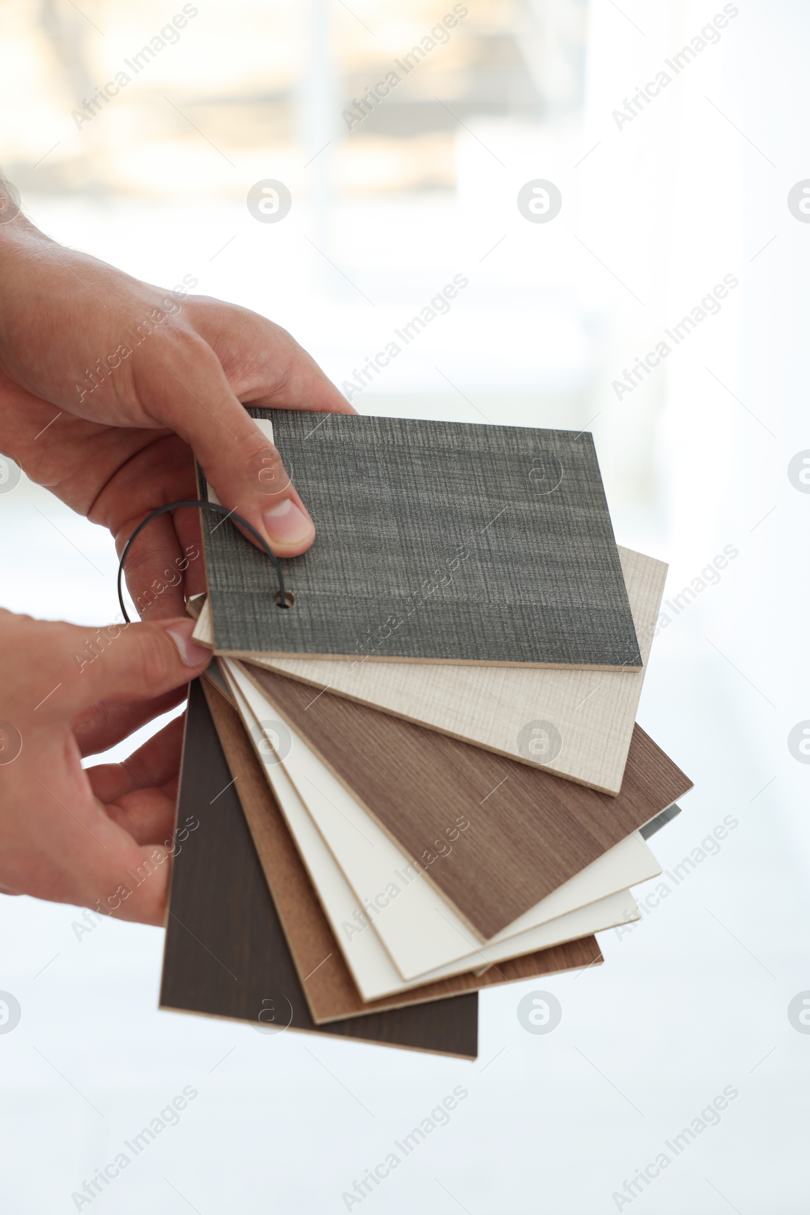 Photo of Man with samples of wooden flooring indoors, closeup