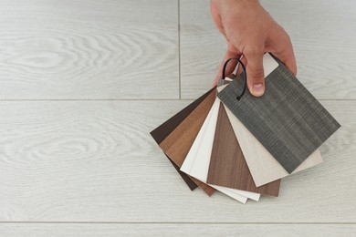 Photo of Man with samples of wooden flooring indoors, closeup. Space for text