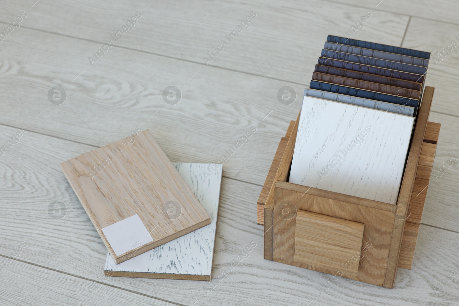 Photo of Different samples of wooden flooring in crate indoors