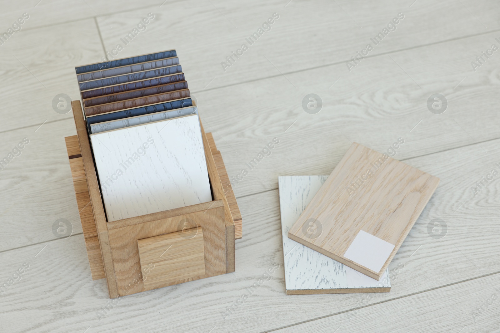 Photo of Different samples of wooden flooring in crate indoors