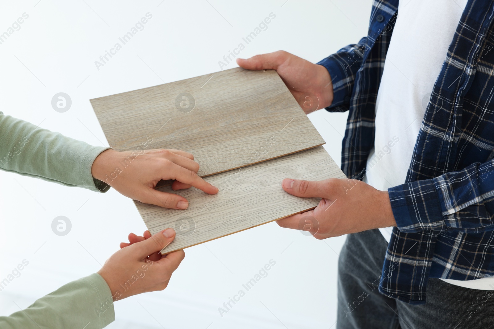 Photo of People choosing samples of wooden flooring indoors, closeup