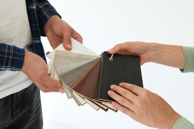 Photo of People choosing samples of wooden flooring indoors, closeup