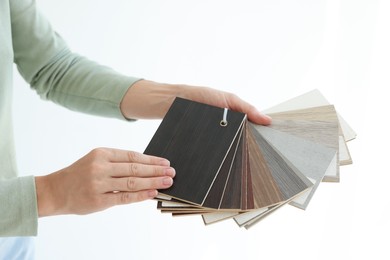 Photo of Woman with samples of wooden flooring indoors, closeup