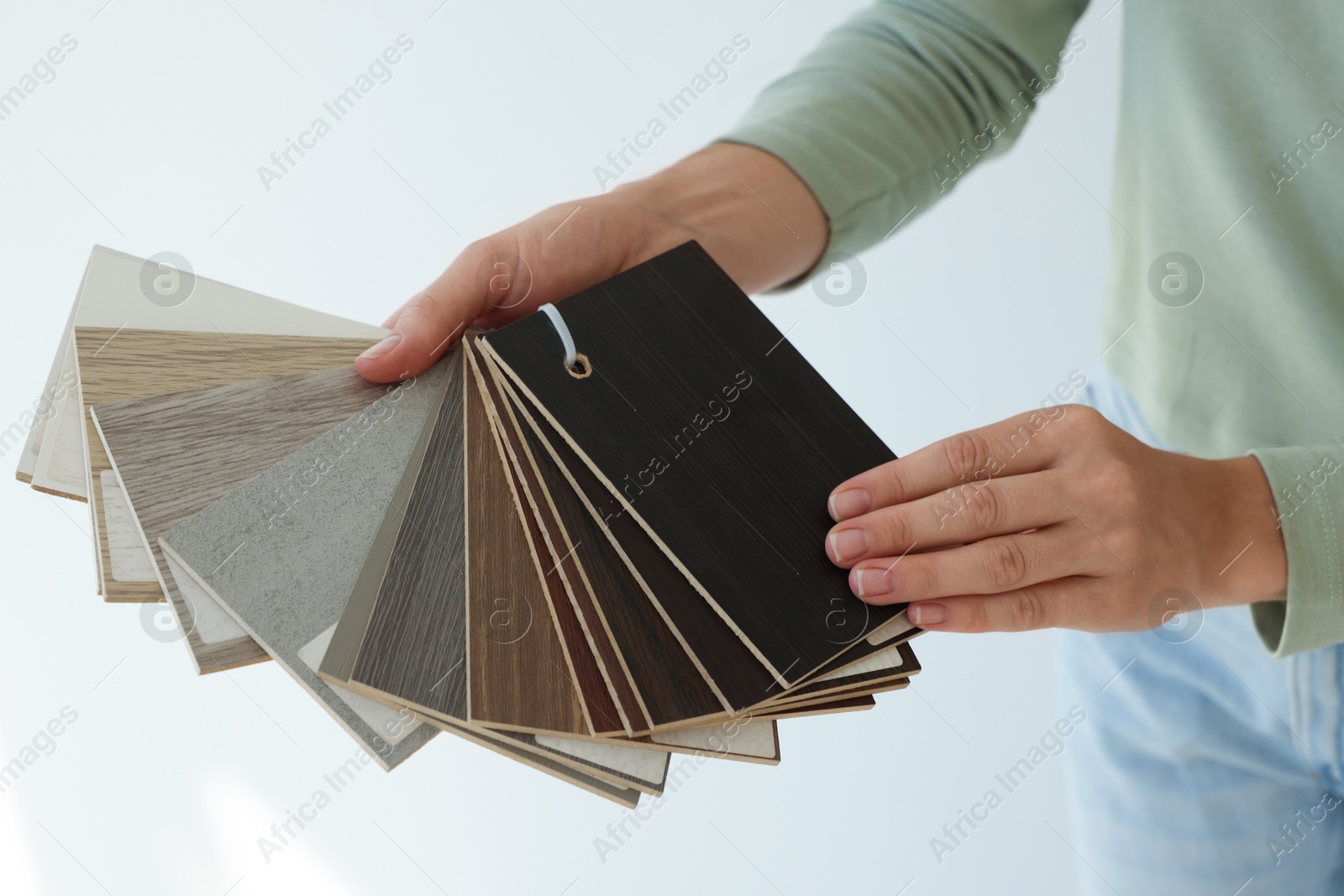 Photo of Woman with samples of wooden flooring indoors, closeup