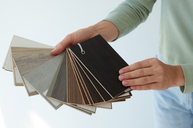 Photo of Woman with samples of wooden flooring indoors, closeup