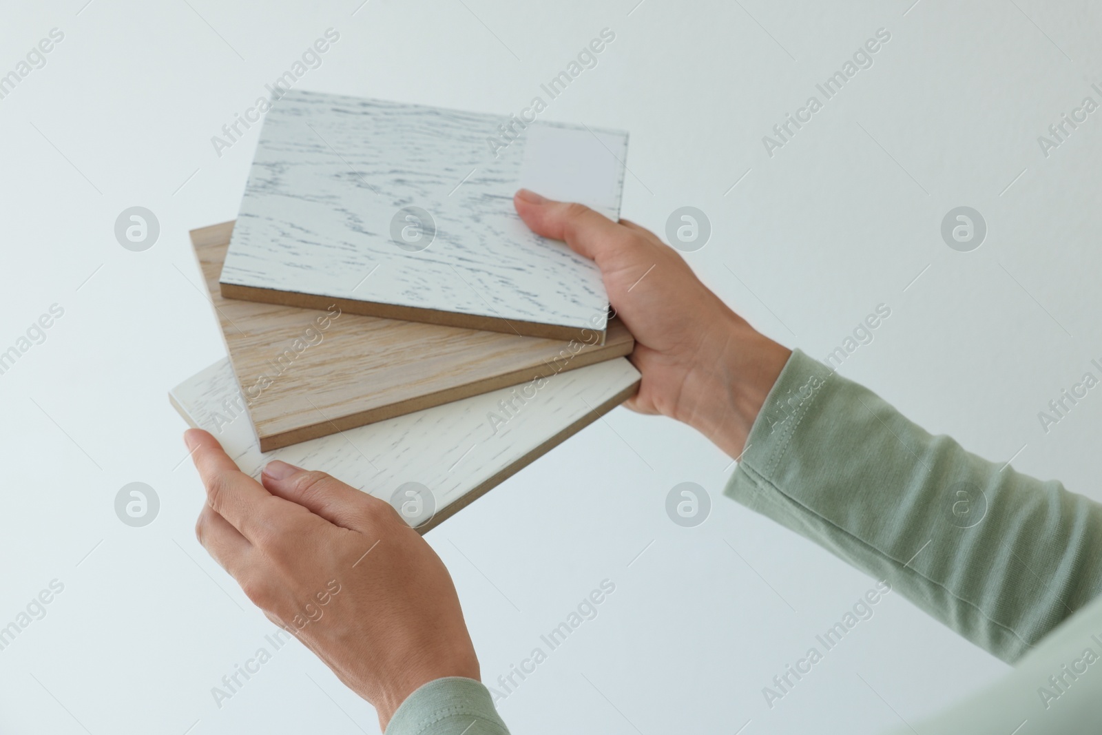 Photo of Woman with samples of wooden flooring indoors, closeup