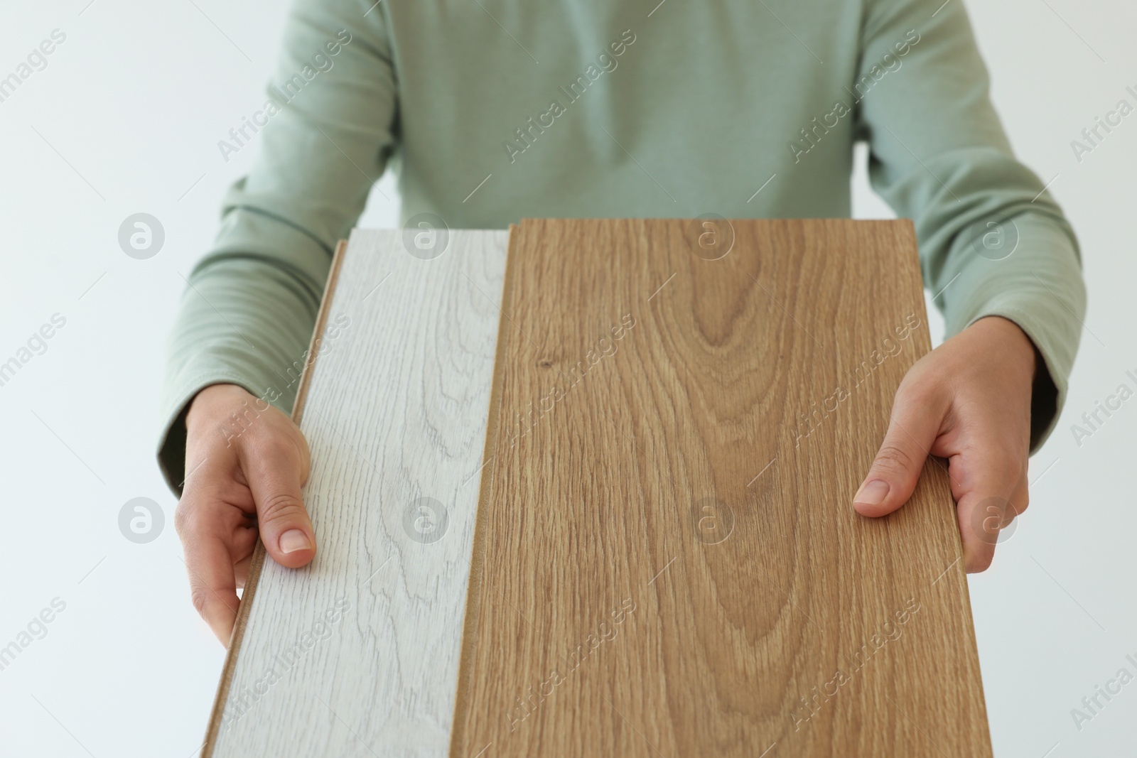 Photo of Woman with samples of wooden flooring indoors, closeup