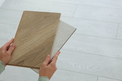 Photo of Woman with samples of wooden flooring indoors, closeup. Space for text