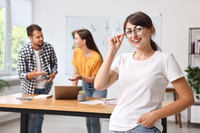 Happy young designer with glasses in office