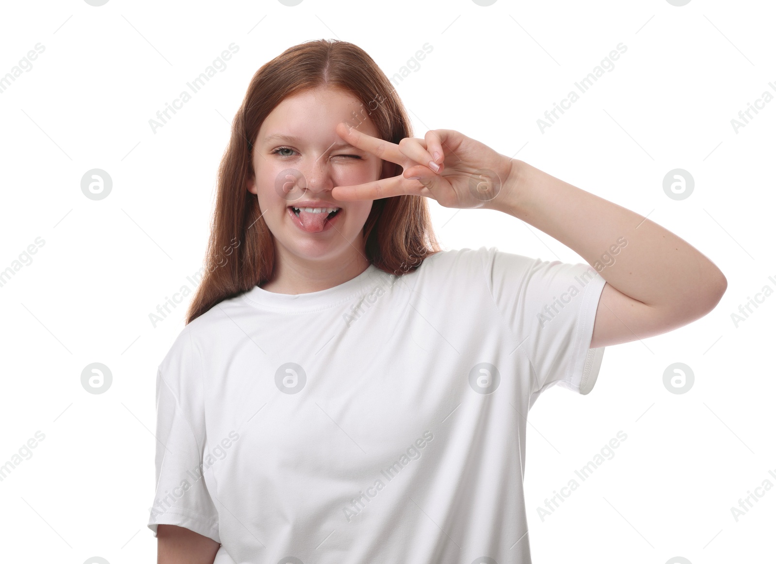 Photo of Teenage girl showing her tongue and v-sign on white background