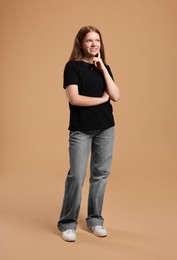 Full length portrait of teenage girl on beige background