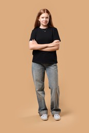 Full length portrait of teenage girl on beige background